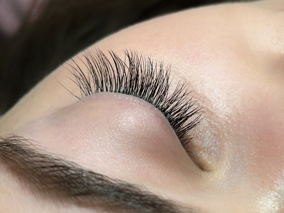 The procedure of classical eyelash extension. Eyelash extension close-up